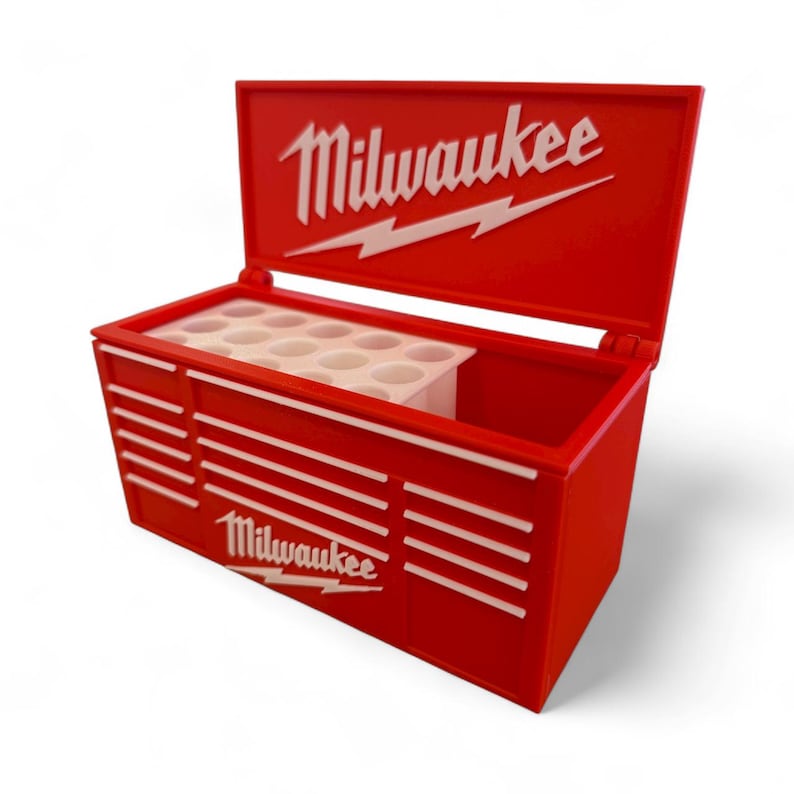 Pu&ograve; includere: Scatola porta attrezzi rossa con dettagli bianchi e il logo "Milwaukee". La scatola ha un coperchio incernierato e un organizer interno bianco. Progettata per riporre attrezzi e accessori.