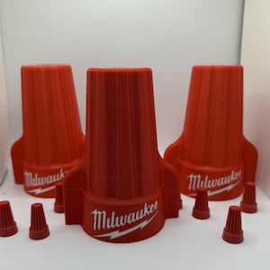 Peut inclure: Trois connecteurs de fil rouge avec le logo Milwaukee et un éclair blanc. Il y a aussi cinq plus petits connecteurs de fil rouge.