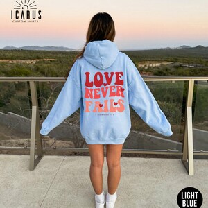 a woman wearing a blue hoodie that says love never ends