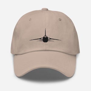 May include: A beige baseball cap with a black embroidered silhouette of a jet airplane on the front.