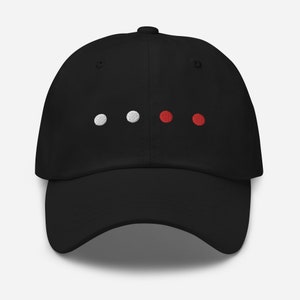 May include: A black baseball cap with white and red embroidered dots on the front.