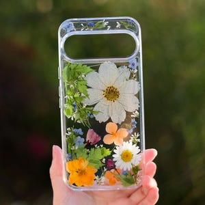 Handgemaakte telefoonhoes met echte geperste weidebloemen, natuurlijke witte botanische harskunst.