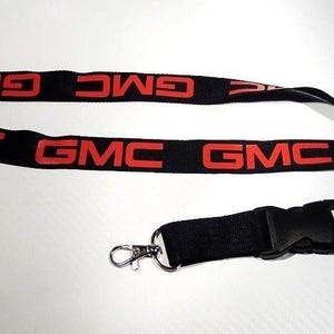 May include: Black lanyard with a silver clip and red "GMC" lettering.