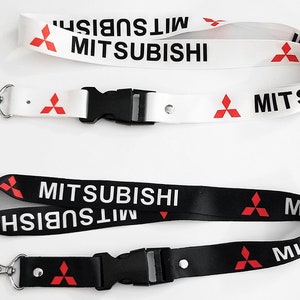 May include: Two black and white lanyards with a red Mitsubishi logo and the word "Mitsubishi" printed on them. The lanyards have a black plastic clip and a silver key ring.