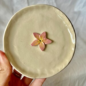 Puede incluir: Un juego de tres tazas de cerámica con un acabado mate moteado. Las tazas son de color crema, gris claro y gris oscuro. Cada taza tiene un diseño simple y minimalista, ideal para café o té.