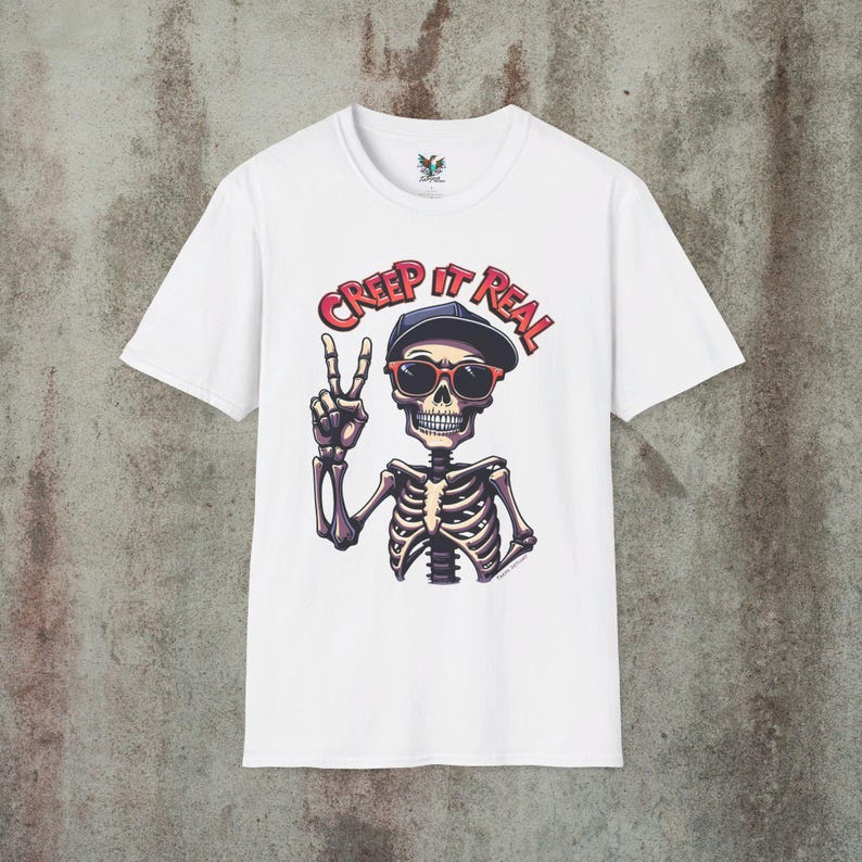 Creep It Real Skeleton T-Shirt featuring a cool illustration of a skeleton flashing the peace sign, wearing sunglasses and a hat, with the slogan Creep It Real on a black unisex t-shirt, perfect for Halloween partygoers and casual wear.