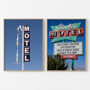 May include: Two framed prints of vintage motel signs. One features a tall sign with the word "MOTEL" in illuminated letters against a blue sky. The other shows a "Starlite MOTEL" sign with a list of amenities.
