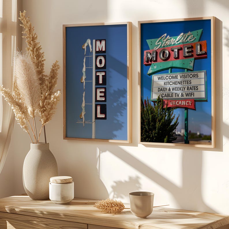 May include: Two framed prints featuring vintage motel signs. One print shows a sign with the word "MOTEL" and figures diving. The other print displays a "Starlite MOTEL" sign with "WELCOME VISITORS" and "VACANCY" text.