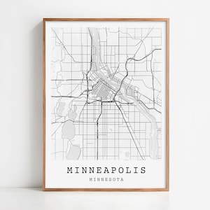 May include: A framed monochrome map print of Minneapolis, Minnesota. The map details the city's layout, including roads, rivers, and green spaces. The city name and state are printed in a minimalist font at the bottom of the print.