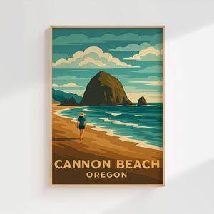 May include: A framed art print depicting a beach scene with a person strolling along the shore. The artwork has a retro travel poster style, with the words "Cannon Beach Oregon" at the bottom. The colour palette includes shades of blue, brown, and green.