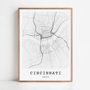 Peut inclure: Une impression encadrée en noir et blanc de la carte de Cincinnati, Ohio. La carte de la ville présente des plans détaillés des rues et des autoroutes. Le nom de la ville et l'état sont imprimés en police sans-serif.