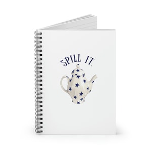 May include: A white spiral bound notebook with a blue and white teapot illustration and the text "SPILL IT." printed on the cover.