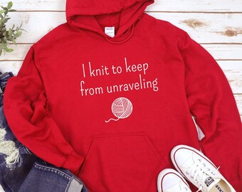 May include: Red hooded sweatshirt with the text "I knit to keep from unraveling" and a white yarn ball graphic.