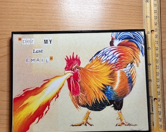 May include: A framed rectangular print featuring a colorful rooster breathing fire, with the text "per MY Last EMAIL" printed in the upper left corner. A wooden ruler placed vertically along the right side shows the print is 11 inches tall.