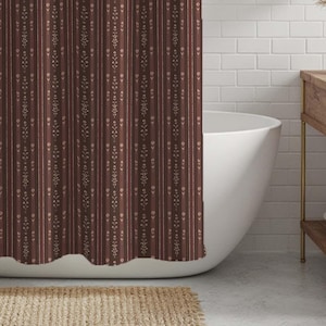 May include: A brown and beige patterned shower curtain hangs in front of a white bathtub. The curtain features vertical stripes with a repeating floral design. The bathroom has white brick-style tiles and a wooden vanity.