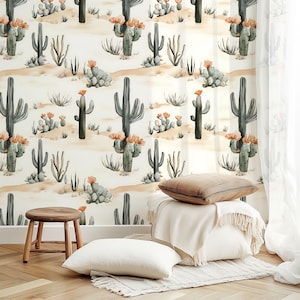 May include: Watercolor-style wallpaper featuring a desert scene with cacti, succulents, and desert plants in shades of green, tan, and orange. The wallpaper is displayed behind a small wooden stool, a white pillow, and a decorative pillow.
