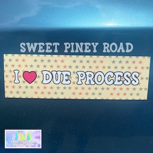May include: A yellow and white bumper sticker with red stars and a pink heart. The sticker says "I ♥ DUE PROCESS" and "SWEET PINEY ROAD ORIGINAL DESIGN".