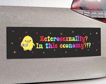 May include: A black bumper sticker with a yellow cartoon chick holding a knife. The text on the sticker reads "Heterosexuality? In this economy?!?" in rainbow colours.