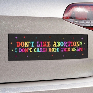May include: Black bumper sticker with rainbow lettering that reads "Don't like abortion? I don't care! Hope this helps."
