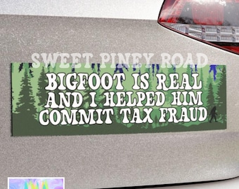 Puede incluir: Una pegatina rectangular para parachoques con el texto "BIGFOOT IS REAL AND I HELPED HIM COMMIT TAX FRAUD" en letras blancas. El fondo es verde con un diseño de bosque. La pegatina está adherida a un vehículo plateado.