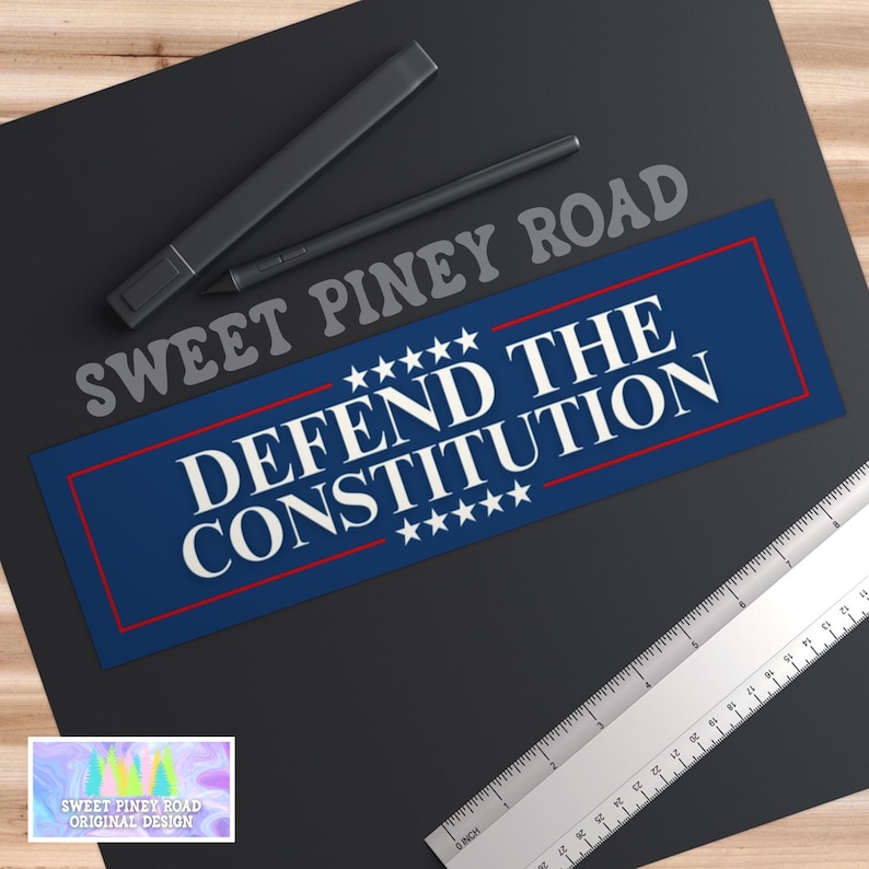 Puede incluir: Pegatina azul y roja con texto blanco que dice "Sweet Piney Road" y "Defend the Constitution" con estrellas a cada lado del texto.