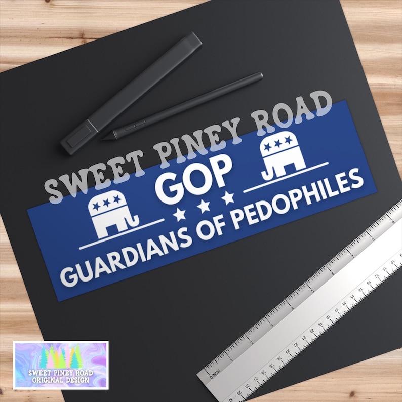 May include: A sticker with the text "SWEET PINEY ROAD" above a blue rectangle with "GOP" and "GUARDIANS OF PEDOPHILES" in white. The sticker also features an elephant graphic and stars. A ruler and pens are also visible.