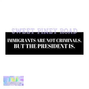 May include: A white background with the text "SWEET PINEY ROAD" in purple. Below is a black rectangle with the text "IMMIGRANTS ARE NOT CRIMINALS, BUT THE PRESIDENT IS." in white. At the bottom is a small, colorful logo.