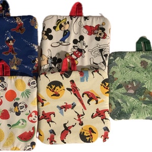 May include: Set of five colorful square pot holders featuring various Disney characters. The pot holders are made of fabric and have a quilted design. The characters include Mickey Mouse, Donald Duck, Goofy, and characters from the movie 'The Incredibles'.
