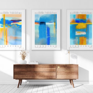 May include: Three abstract art prints with blue, yellow, and orange colors. The prints are titled "Gallery Tegazumi" and "Lindfield".