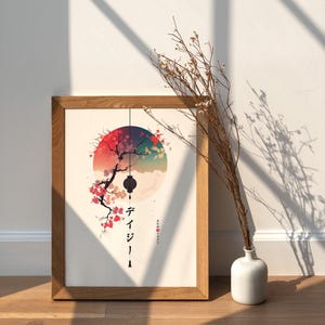 May include: A framed art print featuring a Japanese-inspired design. The artwork depicts a tree with pink blossoms, a hanging lantern, and a colorful sunset. The print is in a wooden frame and is displayed on a wooden surface.