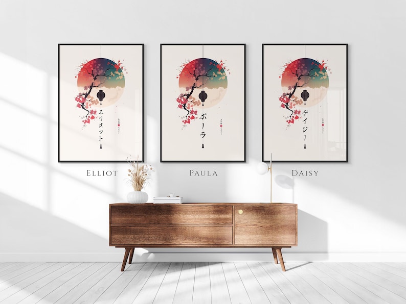 May include: Three framed art prints with Japanese-inspired designs. Each print features a stylized tree with cherry blossoms, a red and blue circular background, and Japanese text. The prints are labeled "Elliot", "Paula", and "Daisy".