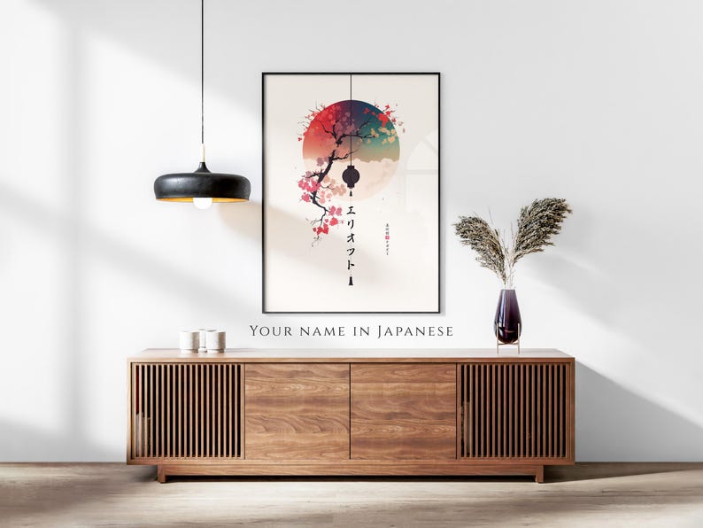 May include: A framed art print featuring a Japanese-inspired design with a red, blue, and green circular background. A black branch with pink blossoms and a lantern hangs in front of the circle. The print hangs above a wooden cabinet.