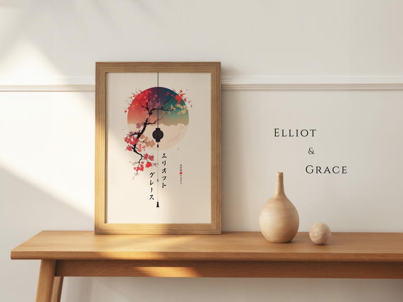 May include: A framed art print featuring a Japanese-inspired design with a red, blue, and white color palette. The artwork includes a cherry blossom branch, a lantern, and Japanese text. A wooden vase and a small sphere sit on a wooden table.