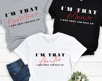 May include: Three t-shirts with text. A gray t-shirt says "I'M THAT God Mama I WILL PRAY AND PULL UP!". A black t-shirt says "I'M THAT Mama I WILL PRAY AND PULL UP!". A white t-shirt says "I'M THAT Auntie I WILL PRAY AND PULL UP!".