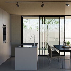 Puede incluir: Una cocina moderna con armarios blancos, un horno de acero inoxidable y una encimera negra. Una mesa de comedor negra con seis sillas est&aacute; en primer plano, y una puerta corredera de vidrio conduce a un patio.