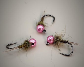 May include: Three pink bead fly fishing lures with brown and green feathers.
