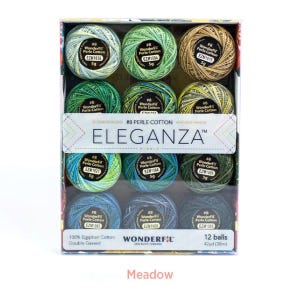 Könnte beinhalten: Ein Set mit 12 Knäueln #8 Eleganza Perlgarn in der Farbsammlung Meadow. Jedes 5g-Knäuel enthält 38m 100% ägyptisches Baumwollgarn. Die Box zeigt eine Vielzahl von Grün-, Blau- und Goldtönen.
