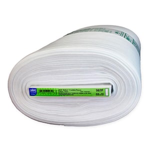 May include: A roll of white Pellon fusible fleece fabric. The roll is cylindrical, with a label that includes the product name, 987F, and other details. The fabric is tightly wound and appears soft and fluffy.