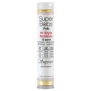 May include: A cylindrical package of Super Bobs Poly M-Style Bobbins. The package is white with gold accents and contains 12 bobbins. Text on the package includes "100wt Polyester" and a quilting guide. The brand name "Superior Threads" is also visible.
