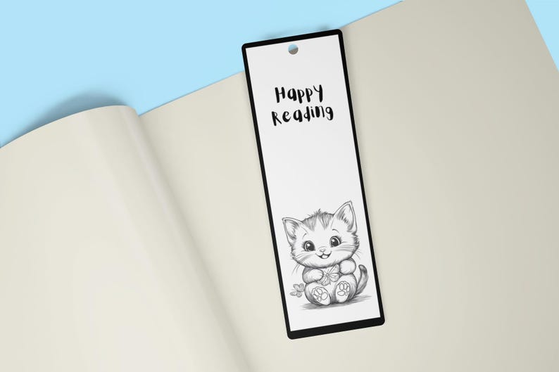 May include: Black and white bookmark with a cute cartoon cat holding a flower. The bookmark has the text "Happy Reading" on it.
