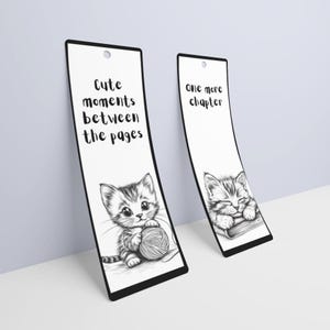 May include: Two black and white bookmark designs featuring a cute kitten. One bookmark says "Cute moments between the pages" and the other says "One more chapter".