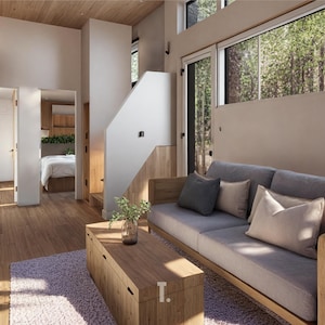 May include: Interior shot of a modern living space with wooden furniture and flooring. A gray sofa with decorative pillows sits against a neutral wall, with a wooden coffee table in front. Large windows offer a view of trees.