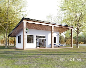 May include: A white modern house with a wooden roof overhang and a covered porch. The house has large windows and a black door. The house is surrounded by trees and grass.