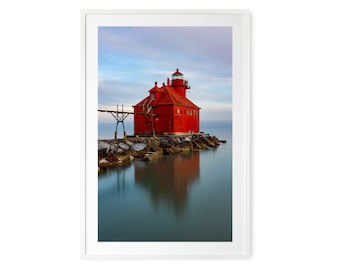 May include: A red lighthouse stands on a rocky outcropping, with a calm, reflective body of water in the foreground. The lighthouse has a white roof and a white lantern on top.