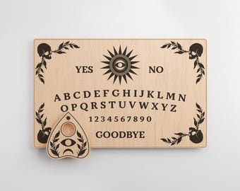 May include: Wooden Ouija board with a black and white planchette. The board features a traditional alphabet, numbers, and the words "YES", "NO", and "GOODBYE".