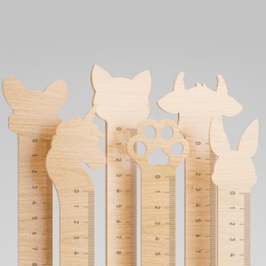 Puede incluir: Seis reglas de madera con forma de diferentes animales, incluyendo un gato, un unicornio, una huella de pata, un ciervo, un conejo y un perro. Cada regla tiene una escala marcada en pulgadas de 0 a 8.