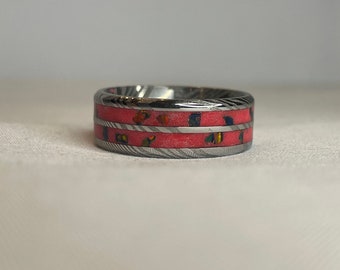 Custom Damascus double inlay ring with black opal and red inlay powder. Glows neon greenish.