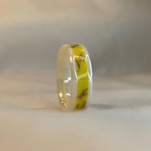 Individueller weißer Keramikring mit gelbem Inlay, Kupferspänen und Glanzpulver.