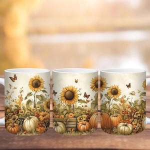 May include: White ceramic mugs with a fall-themed design. The mugs feature sunflowers, pumpkins, and butterflies in a watercolor style. The design includes a wooden crate filled with pumpkins and sunflowers. The mugs are set against a blurred background.