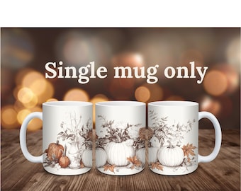 May include: A white ceramic mug featuring a detailed botanical illustration of pumpkins, autumn leaves, and flowers in shades of brown and orange. The text "Single mug only" is printed in white above the mug. The design wraps around the exterior.